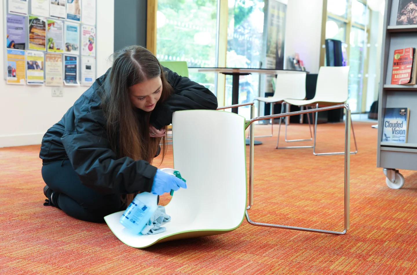 A person cleaning a white chair