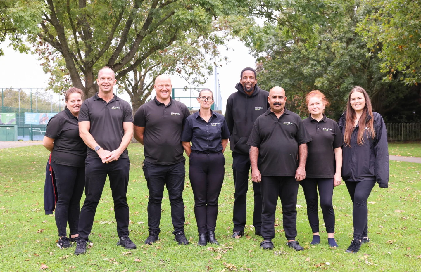 This is a group of 8 people standing together all dressed in black.