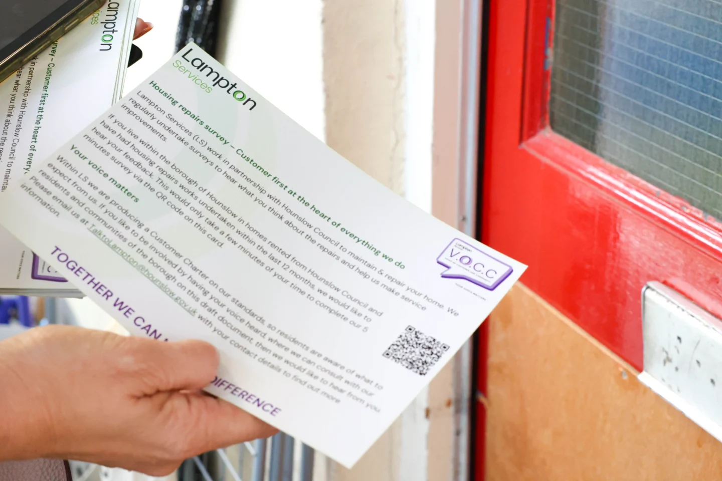 A hand inserting a Lampton notification through the letter box